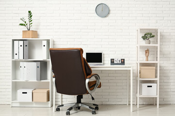 Workplace with laptop and flip calendar in office interior