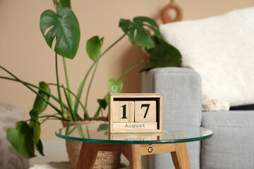 Cube calendar with date 17 AUGUST on table in living room, closeup