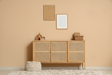 Interior of living room with commode, blank frames and cube calendar