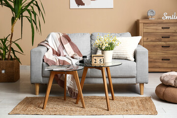 Interior of living room with sofa, tables and cube calendar