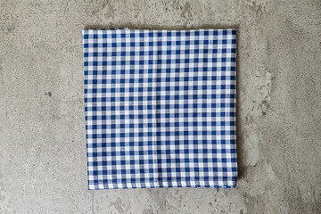 grey or gray cement table with blue and white tablecloth or napkin. View from top. Empty tablecloth...