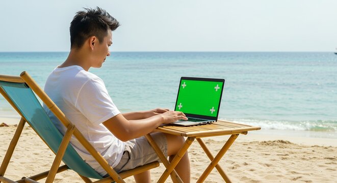 Young Man Working Remotely on Laptop with Green Screen on Tropical Beach - Powered by Adobe