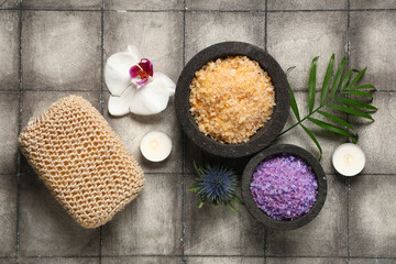Fototapeta na wymiar Beautiful spa composition with bowls of sea salt and candles on grey grunge background