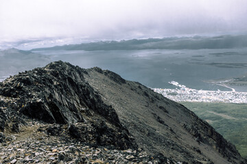 Navigating the jagged stone path under clear skies with glaciers gleaming on distant peaks