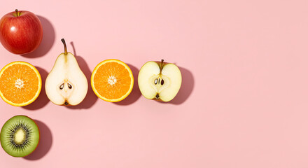 Red apple sliced orange pear kiwi on pink background