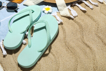 Composition with beach shoes and beach accessories on sand as background, closeup
