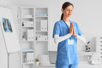 Female doctor meditating in clinic