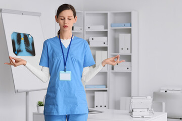 Female doctor meditating in clinic