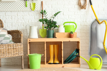Gardening tools with plants on stand in workshop