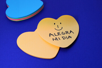 HAPPY FACE AND PHRASE BRIGHTENS MY DAY, heart-shape sticky notes (Spanish text)