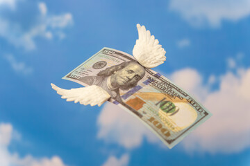 A hundred-dollar bill with small white wings. Money flying away, financial loss concept.