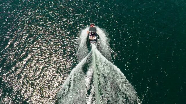 Wake boat surf boat driving sunny day aerial drone slow motion