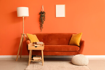 Interior of stylish living room with red sofa, table and lamp