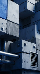 Abstract architectural detail featuring stacked concrete cubes, pipes, and ventilation, creating a geometric and industrial aesthetic.