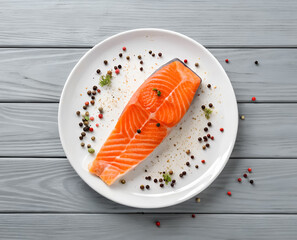 Top view of single raw salmon piece with pepper and other spices in white ceramic plate on gray wooden background and generated with AI