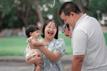 Joyful Family Moment in a Park with Parents and Child Smiling