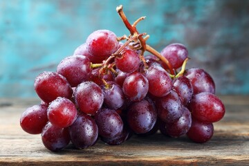Fototapeta premium Cluster of red grapes on a wooden surface