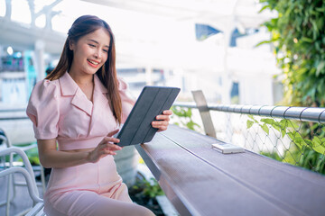 Shot of elegant business woman smiling and using tablet.