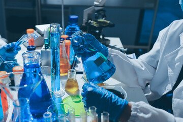 Scientist pipetting medical samples into microplate in laboratory