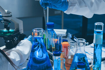 Scientist pipetting medical samples into microplate in laboratory