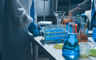 Scientist pipetting medical samples into microplate in laboratory