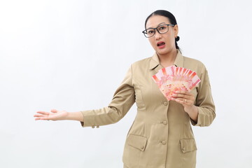 Confused young asian teacher holding Indonesian banknotes while showing asking gesture