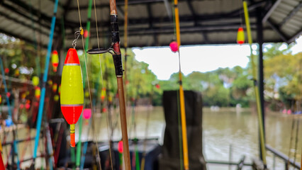 A row of fishing rods with spinning reels neatly arranged on a wooden rack. The image showcases...