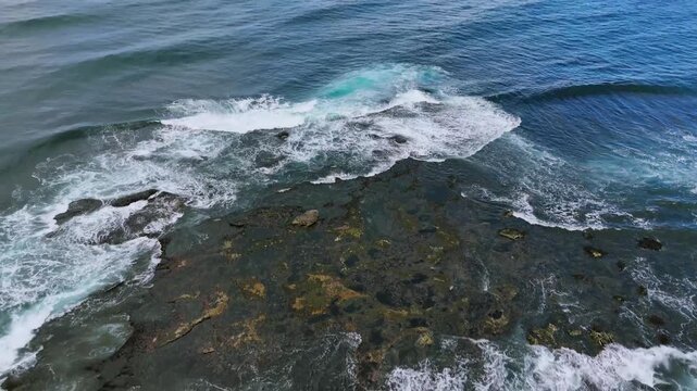 Cronulla Beach, Sydney, Australia &ndash;UHD Drone Video- Close up view, flying in a circle over the Shark &lsquo;island&rdquo; &ndash;a small Rock Islet with interesting texture, barely showing above the waves.