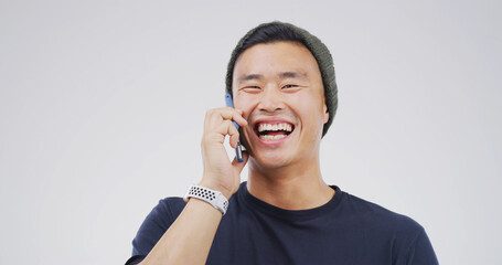 Laugh, phone call and happy Asian man in studio for communication, joke or funny story. Mobile,...