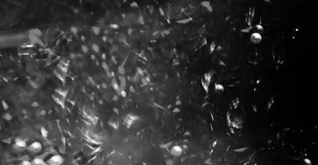 Black and white tones dominate abstract glowing background with scattered reflections and soft gradients. Monochrome light creates contrast and surreal atmosphere. abstract background use for design.