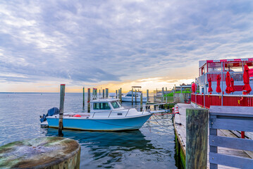 Boats next to the ocean in a wooden trail during sunset.