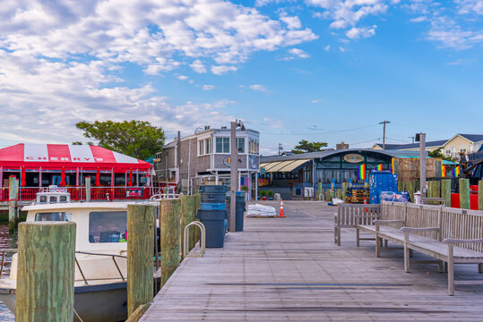 Fire Island, New York State, United States of America, 7 June 2024. Cherry Grove pier and dock, hotels, bars, restaurants, shops and pride flags.