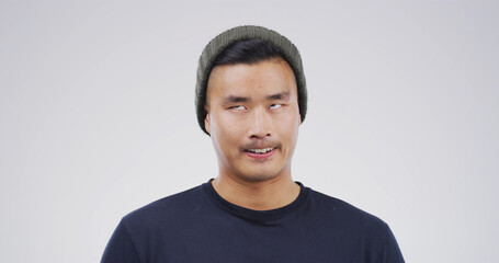 Silly, rolling eyes and Asian man in studio with funny face for playful, comedy and humor on white...