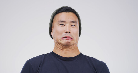Comic, funny face and portrait with man on studio space for emotions, humor or silly joke. Comedy, emoji and unique with goofy Asian person isolated on white background for crazy or quirky reaction