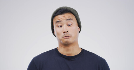 Comic, funny face and goofy with man on studio space for emotions, humor or silly joke. Comedy, emoji and unique with Asian person isolated on white background for quirky expression or reaction