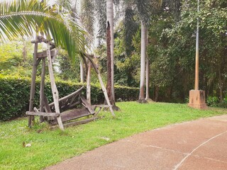 A wooden chair in a park in a state of disrepair
