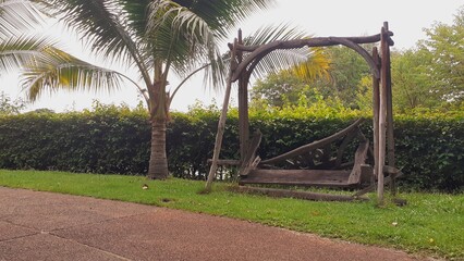 A wooden chair in a park in a state of disrepair