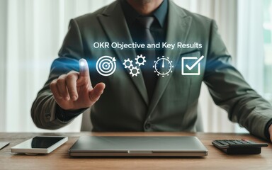 OKR Concept Man in suit interacting with holographic display showcasing Objectives and Key Results at the desk.