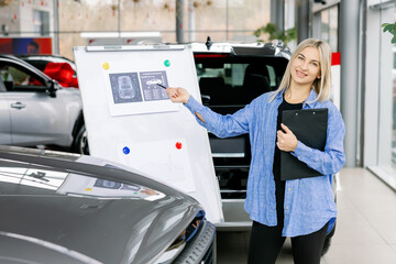 Saleswoman presenting technical data and charts on whiteboard in car dealership