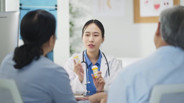 Asian doctor in uniform attentively assists a senior couple with medical paperwork in a hospital area, explaining health records and test results with care and professionalis senior health	