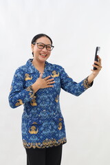 Relieved young civil servant woman holding cell phone while touching her chest