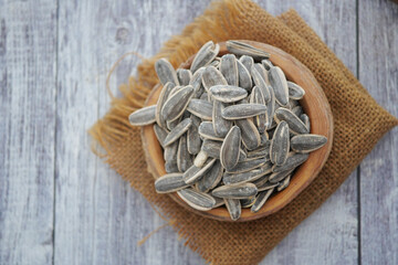 Bowl of roasted sunflower seeds on a wooden surface