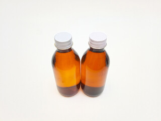 Amber glass bottles with aluminum caps on a white background, two brown glass bottle for pharmaceuticals, syrups, essential oils, and cosmetics,