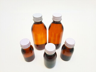 Different Size Amber glass bottles with aluminum caps on a white background, many brown glass bottle for pharmaceuticals, syrups, essential oils, and cosmetics,,