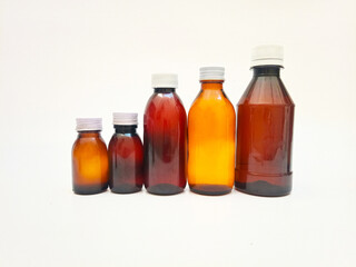 Different Size Amber glass bottles with aluminum caps on a white background, many brown glass bottle for pharmaceuticals, syrups, essential oils, and cosmetics,,