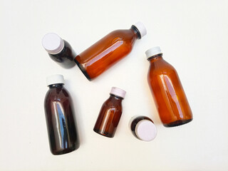Different Size Amber glass bottles with aluminum caps on a white background, many brown glass bottle for pharmaceuticals, syrups, essential oils, and cosmetics,,