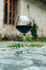 Glass of Red Wine in Front of Stone Wine Cellar in France or Italy
