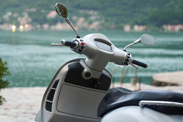 Electric scooter waiting by calm harbor coast
