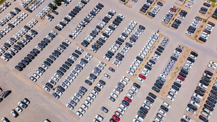 Straight rows of new cars in a factory parking lot