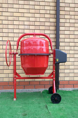 New red concrete mixer, general view. Construction tool for preparing concrete mix.